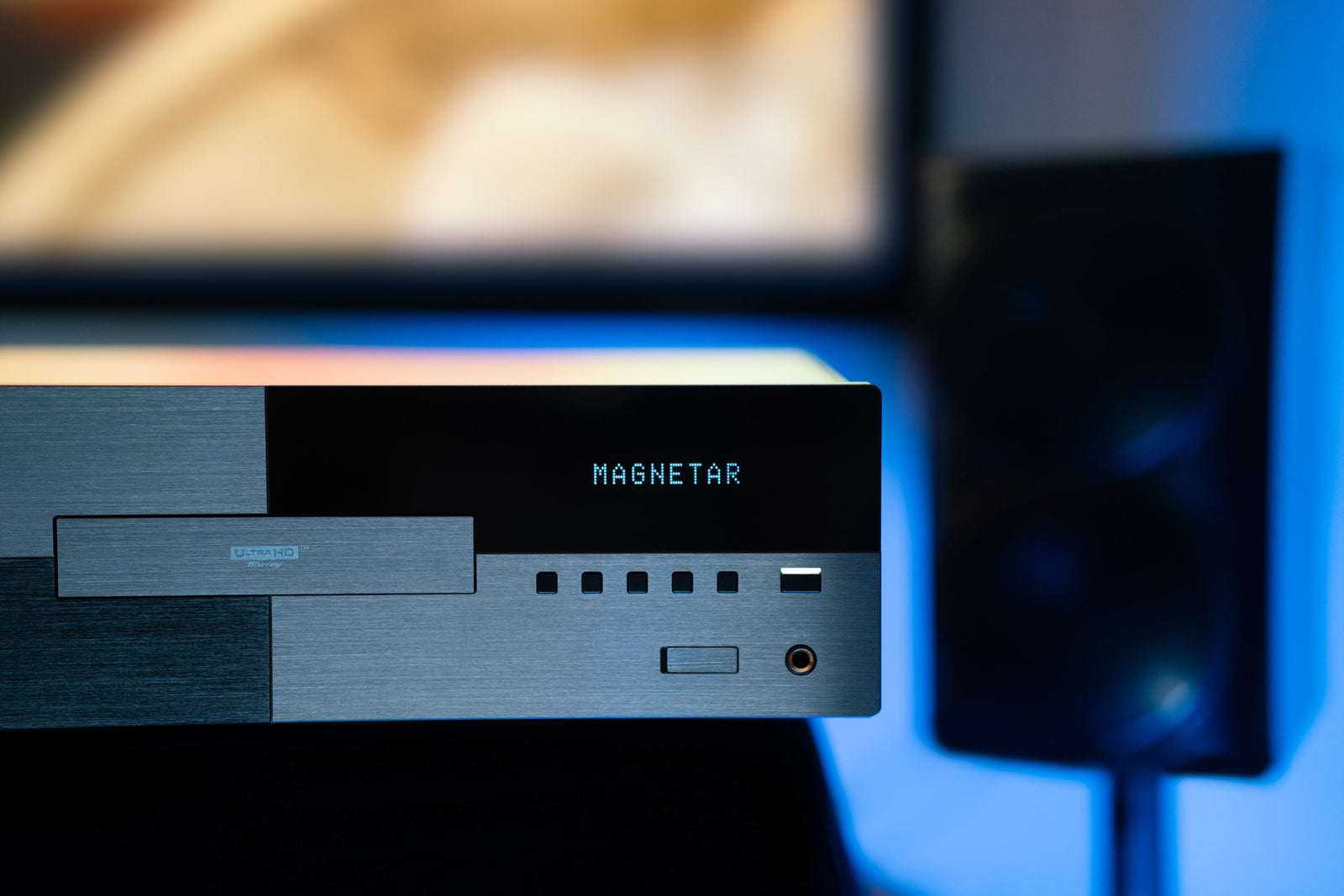 A Magnetar UDP900 in a modern living room with a flat screen television and home theater system in the background.